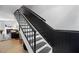 Elegant staircase featuring contrasting black and white colors and a view of the living space at 7708 Falcon Rest Cir, Raleigh, NC 27615