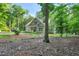 Serene outdoor setting with wooded surroundings and a glimpse of the home at 8226 Mcarthur Park Dr, Efland, NC 27243