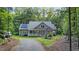 Charming home with a welcoming front porch and solar panels nestled among lush trees at 8226 Mcarthur Park Dr, Efland, NC 27243
