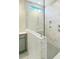 Modern bathroom with marble-patterned walls and glass-enclosed shower with stylish fixtures and grey tile flooring at 89 Merle Dr, Wendell, NC 27591