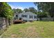 Backyard view of the home, displaying a wooden deck and ample lawn space at 101 Goldston Dr, Carrboro, NC 27510
