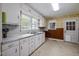 Functional kitchen with white cabinetry, stainless steel sink, and natural light from multiple windows at 101 Goldston Dr, Carrboro, NC 27510