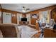 Cozy wood-paneled living room featuring a ceiling fan and abundant natural light from the windows at 101 Goldston Dr, Carrboro, NC 27510