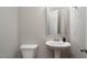 A bright half bathroom features a pedestal sink, white toilet, and modern fixtures at 1018 Excite Ave, Morrisville, NC 27560