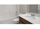 Modern bathroom with white tiling, vanity with a light countertop, and a shower-tub combo at 1018 Excite Ave, Morrisville, NC 27560