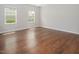 A sun-drenched bedroom with hardwood floors features two large windows and natural light at 1018 Excite Ave, Morrisville, NC 27560
