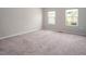 Spacious bedroom featuring two windows, carpet floors, and neutral color walls at 1018 Excite Ave, Morrisville, NC 27560