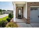 Inviting front porch with brick accents, manicured shrubs, and a stylish glass front door at 1018 Excite Ave, Morrisville, NC 27560