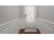 A hallway features hardwood floors, white wainscoting, and a rear door with a decorative curtain at 1018 Excite Ave, Morrisville, NC 27560
