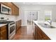 A well-lit kitchen features wooden cabinets, stainless steel appliances, a white tile backsplash and a sliding glass door at 1018 Excite Ave, Morrisville, NC 27560
