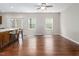 An open floor plan living room features hardwood floors, a ceiling fan, natural light and access to the kitchen at 1018 Excite Ave, Morrisville, NC 27560