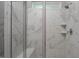 Elegant walk-in shower featuring marble-look tile, glass door, and built-in niche at 1018 Excite Ave, Morrisville, NC 27560