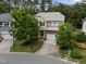 Aerial view of a two-story home nestled in a tree-filled neighborhood with well-manicured lawns and a paved driveway at 1040 Bellenden Dr, Durham, NC 27713