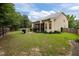 Green backyard with a stone patio, seating area, screened porch, and lush surroundings at 1040 Bellenden Dr, Durham, NC 27713
