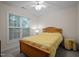 Cozy bedroom features a ceiling fan, carpet, and a large window illuminating the bed and side table at 1040 Bellenden Dr, Durham, NC 27713