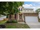 Charming two-story home featuring stone accents, a two-car garage, and a welcoming front entrance with brick steps at 1040 Bellenden Dr, Durham, NC 27713