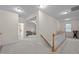 Bright hallway offers views of a bathroom and living room with neutral walls and a stairway with white railing at 1040 Bellenden Dr, Durham, NC 27713