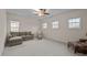 Spacious living room with light carpet, a ceiling fan, multiple windows, and comfortable seating arrangement at 1040 Bellenden Dr, Durham, NC 27713
