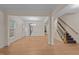 Spacious living room with hardwood floors, natural light, and a staircase with carpeted steps at 1040 Bellenden Dr, Durham, NC 27713