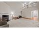 Large living room with a fireplace, carpeted flooring, and adjacent staircase at 1040 Bellenden Dr, Durham, NC 27713