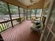 Cozy screened porch with wood flooring, ceiling fan, wicker furniture, and outdoor views at 1040 Bellenden Dr, Durham, NC 27713