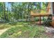 Lush backyard with deck, mature trees, a trampoline and ample room for outdoor activities at 106 Lattimore Ln, Durham, NC 27713