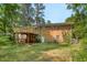 Backyard featuring brick home with deck and natural green space with mature trees at 106 Lattimore Ln, Durham, NC 27713