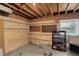 Unfinished basement featuring brick walls, a window for natural light, and shelving at 106 Lattimore Ln, Durham, NC 27713