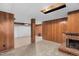 Large basement area with wood paneling, a brick fireplace, and unfinished ceiling at 106 Lattimore Ln, Durham, NC 27713