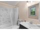 Bright bathroom with a tub and shower combination and white marble tiled walls at 106 Lattimore Ln, Durham, NC 27713