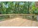 Wooden deck with railing overlooking a green backyard area with lush trees at 106 Lattimore Ln, Durham, NC 27713