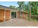 Wooden deck and brick house with sliding glass door for indoor-outdoor living and backyard view at 106 Lattimore Ln, Durham, NC 27713