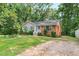 Charming brick and siding home with a well-maintained front yard and a gravel driveway at 106 Lattimore Ln, Durham, NC 27713