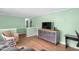 Open living room layout with hardwood floors, light green walls, and a view into other rooms at 106 Lattimore Ln, Durham, NC 27713