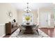 Staged dining room with hardwood flooring, a modern chandelier, and a large window with shutters at 1090 Indigo Ridge Pl, Cary, NC 27519