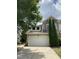 Stone and siding exterior with a white garage door, manicured lawn, and mature evergreens at 1090 Indigo Ridge Pl, Cary, NC 27519