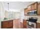 Kitchen with stainless steel appliances, wooden cabinets, and hardwood flooring at 1090 Indigo Ridge Pl, Cary, NC 27519