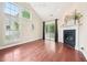Open-concept living room with fireplace, hardwood floors, and tall windows at 1090 Indigo Ridge Pl, Cary, NC 27519