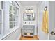 Bathroom featuring gray vanity with sink, drawers, and shelf; with an updated mirror and lighting at 1104 Englewood Ave, Durham, NC 27701