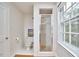 Bright bathroom with tile flooring, toilet, stand up shower, and large window offering natural light at 1104 Englewood Ave, Durham, NC 27701