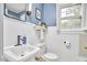 Bathroom with white vanity, framed mirror, white wainscoting, blue accent wall and natural light at 1104 Englewood Ave, Durham, NC 27701