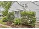 Charming white exterior of a home with a screened porch, landscaped yard, and flowering bushes at 1104 Englewood Ave, Durham, NC 27701