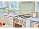 Updated kitchen features stainless steel stove and oven, white cabinets, and natural light at 1104 Englewood Ave, Durham, NC 27701