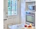 Kitchen features stainless steel oven and microwave with white cabinets and door leading to the exterior at 1104 Englewood Ave, Durham, NC 27701