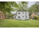 View of the home's rear exterior with a deck and a well-maintained lawn at 1104 Englewood Ave, Durham, NC 27701