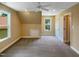 Spacious bedroom features neutral walls, gray carpeting, a ceiling fan, and windows overlooking the backyard at 1201 Dagmar Ln, Wake Forest, NC 27587