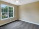 This bedroom features neutral walls, gray carpeting, a ceiling fan, and a window overlooking the backyard at 1201 Dagmar Ln, Wake Forest, NC 27587