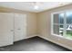 This bedroom features neutral walls, gray carpeting, a ceiling fan, and a window overlooking the backyard at 1201 Dagmar Ln, Wake Forest, NC 27587
