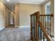 This hallway offers a wood railing, carpeted floors, neutral walls and natural light at 1201 Dagmar Ln, Wake Forest, NC 27587