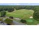 Breathtaking aerial view of the green golf course surrounded by mature trees and a paved road with parked cars at 124 Kingsport Rd, Holly Springs, NC 27540